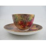 A Royal Worcester cup and saucer, the exterior of the cup and the saucer decorated with fruit to a