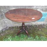 A 19th century oak tilt top tripod table, diameter 27ins