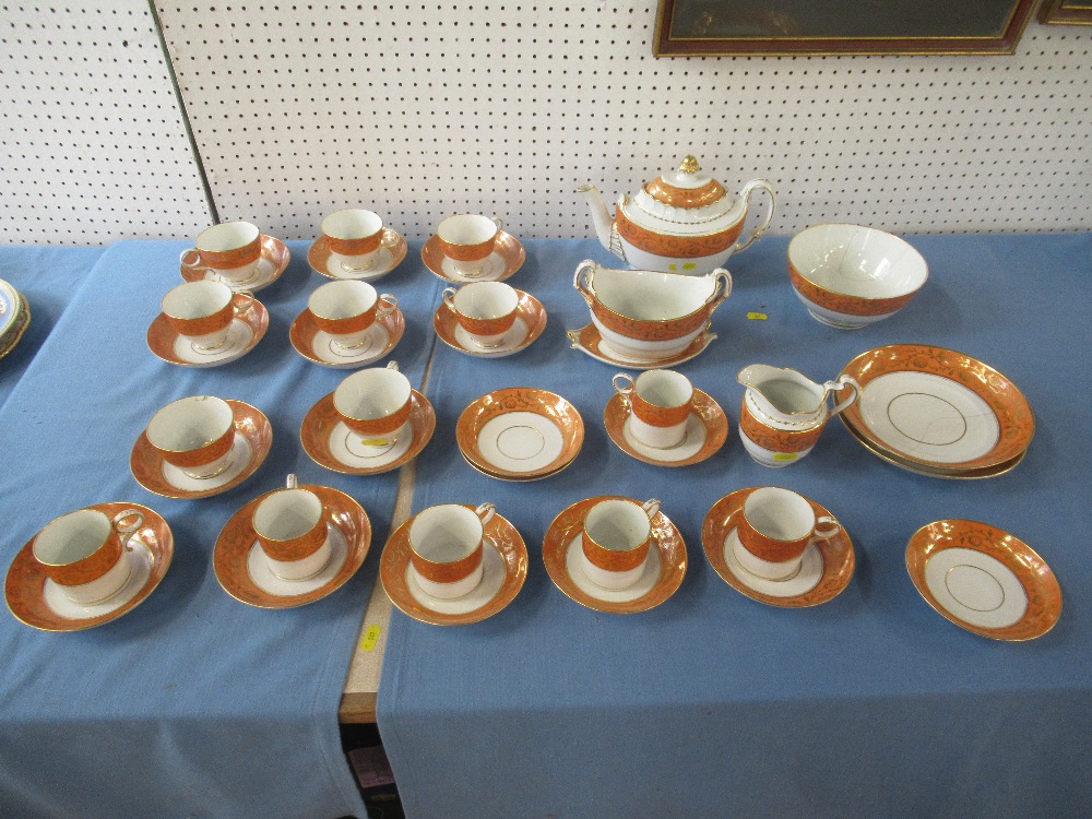 A Barr's Worcester part service decorated with amber bands with scrolls , gilt and pomegranate