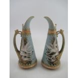 A pair of left and Right Royal Worcester jugs each decorated with four swans on a powder blue ground