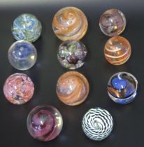 A collection of eleven assorted glass paperweights, by various manufacturers, some boxed.