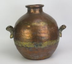 A large Middle eastern copper jar of ovoid form with cast brass loop carrying handles to the