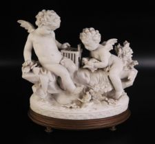 A continental bisque porcelain figure group of cherubs with birdcage and birds, on a naturalistic