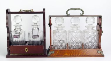 An Edwardian oak Tantalus with Betjemann's patent locking mechanism, containing three clear glass