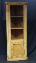 A stripped pine corner cupboard, having a moulded cornice above three open shelves with cupboard
