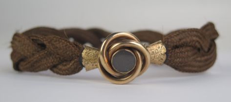 A Large Victorian Platted Hair Bracelet with chased yellow metal mounts and double sided locket,