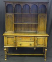 A reproduction oak dresser, the upper part with moulded cornice, and arrangement of shelves enclosed