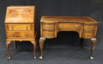 A reproduction walnut and crossbanded dressing table, of inverted serpentine outline, the shaped