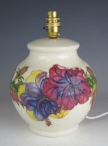 A Moorcroft pottery table lamp of globular form with Hibiscus decoration to an ivory ground, overall