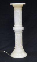 A alabaster torchiere stand, with carved low relief floral decoration fitted with an internal light,