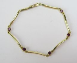 An 18ct Gold and Ruby Bracelet with five c. 2.95mm rub over set stones, London hallmarks, 6.75" (