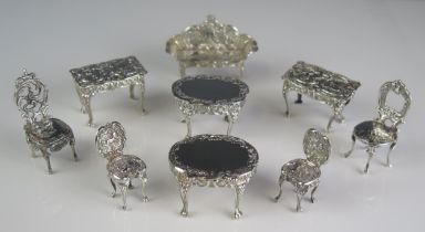 A collection of English and continental silver miniature furniture, includes two pairs of side