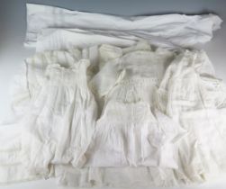 A collection of linen petticoats, christening gown, some with cut-work decoration and lace edging.