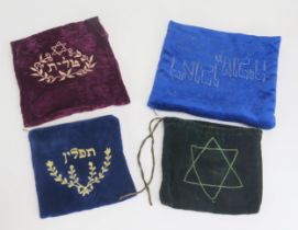 Four assorted tallit velvet bags with Hebrew script and motifs.