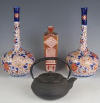 A pair of Japanese Imari porcelain bottle vases, with all-over floral decoration, with slender