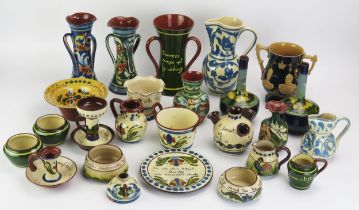A collection of Torquay pottery wares, includes jugs, vases, chamberstick, and twin handled vase