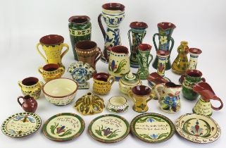 A collection of Torquay pottery wares, includes candlesticks, vases, jugs, plates and dishes.