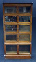 A Minty style oak five section bookcase, each section with a pair of glazed panelled doors, on a