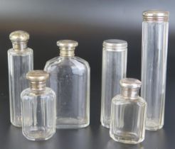 A collection of assorted clear glass and silver mounted dressing table jars and flasks, various