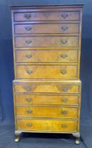 A reproduction walnut veneered chest on chest, the upper part with moulded cornice, containing