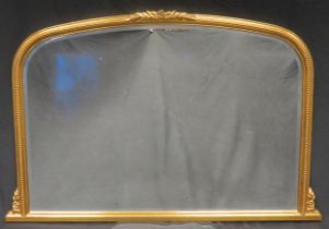 A gilt framed overmantel mirror, of arched outline with bevelled mirror plate and beaded decorated