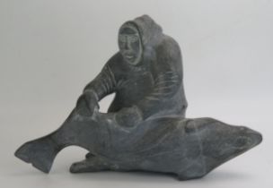 An Inuit carved hardstone figure group of an Eskimo with a baby killer whale, inscribed to the