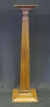 A mahogany torchere stand with fluted square tapering column on a stepped square base, 137cm high,