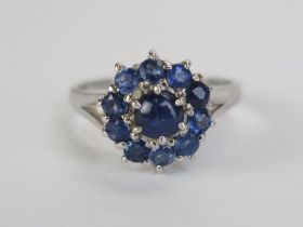 An 18ct White Gold and Blue Stone Cluster Ring set with a central 4.95mm cabochon cut, 12.5mm