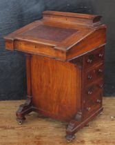 A Victorian walnut and satinwood strung davenport, with hinged writing surface enclosing a fitted