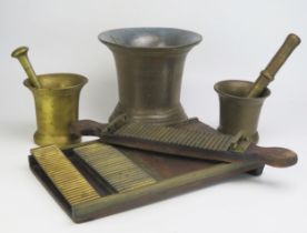 A large cast brass mortar, 20cm high, two smaller bronze pestle and mortars and a pill making