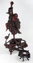 A Chinese carved root wood figure of a dancing man, 66cm high, a wood stand, a carved wood plaque