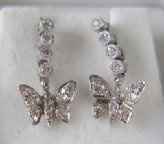 A Pair of Diamond Butterfly Pendant Earrings in a precious white metal setting, with four