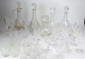 A collection of cut glass drinking vessels including wine glasses, tumblers, and assorted decanters.