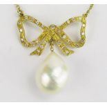 An 18ct Gold, and Baroque Pearl or Cultured Pearl Necklace suspended beneath a diamond set bow and