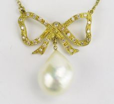 An 18ct Gold, and Baroque Pearl or Cultured Pearl Necklace suspended beneath a diamond set bow and