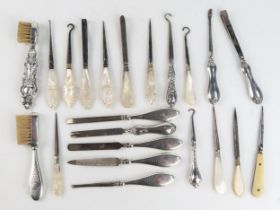 A collection of silver handled and mother-of-pearl handled manicure items, nail files, button hooks,