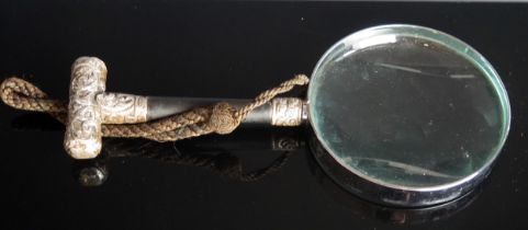 A magnifying glass with ebonised and silver mounted handle, 23cm long.