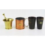 A pair of horn beakers, 10.5cm high, a brass pestle and mortar, a copper measure. (4).