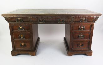 A late Victorian oak twin pedestal desk, the rectangular top with inset leather writing surface,