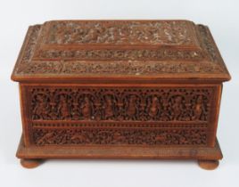 An Indian carved sandalwood casket, of rectangular outline, with shallow domed hinged lid, with