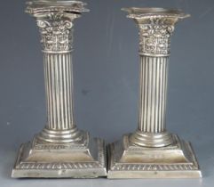 A pair of Victorian Corinthian column candlesticks, all marks worn, London, Birmingham, 1897, on