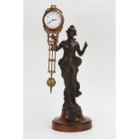 A bronzed metal mystery timepiece, modelled as a young lady standing in a flowing dress holding