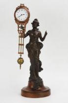 A bronzed metal mystery timepiece, modelled as a young lady standing in a flowing dress holding
