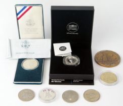 A 10 Euro proof coin, a 1990 American proof silver dollar, commemorative crowns. and medallions.