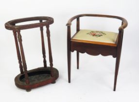 An Edwardian mahogany piano stool, with swept back rail, .hinged seat raised on four square tapering