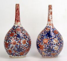 A matched pair of Japanese Imari porcelain bottle vases, with all over floral decoration, 21cm high.