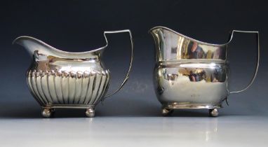 A George III silver cream jug, all marks worn, 14cm long, together with another silver cream jug,