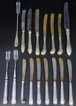 A collection of silver handled butter knives, table knives, and pickle forks.
