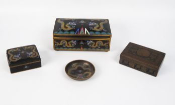 A Chinese cloisonné box with hinged lid decorated with dragons chasing pearls to a black ground, a