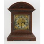An Edwardian oak cased mantel clock, of arched outline, the 15cm brass dial with silvered chapter